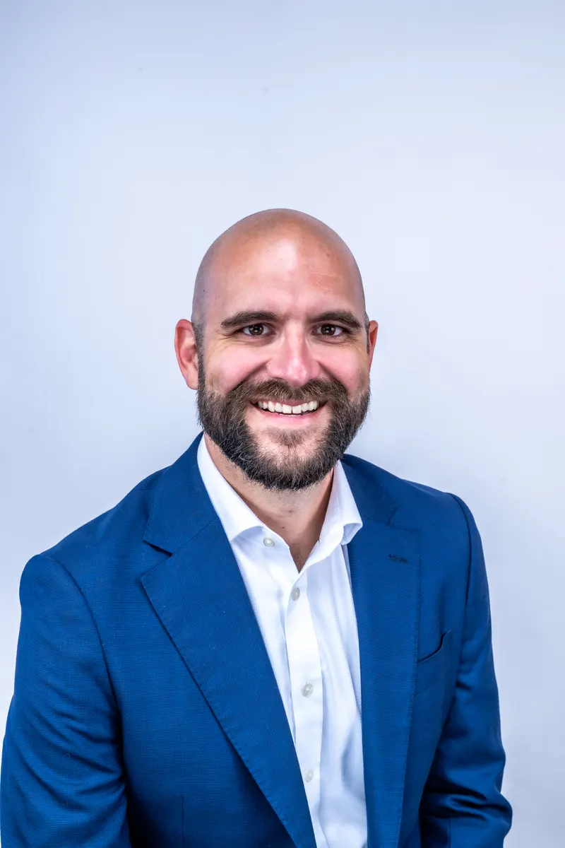 Nic Zateslo smiling in a blue suit